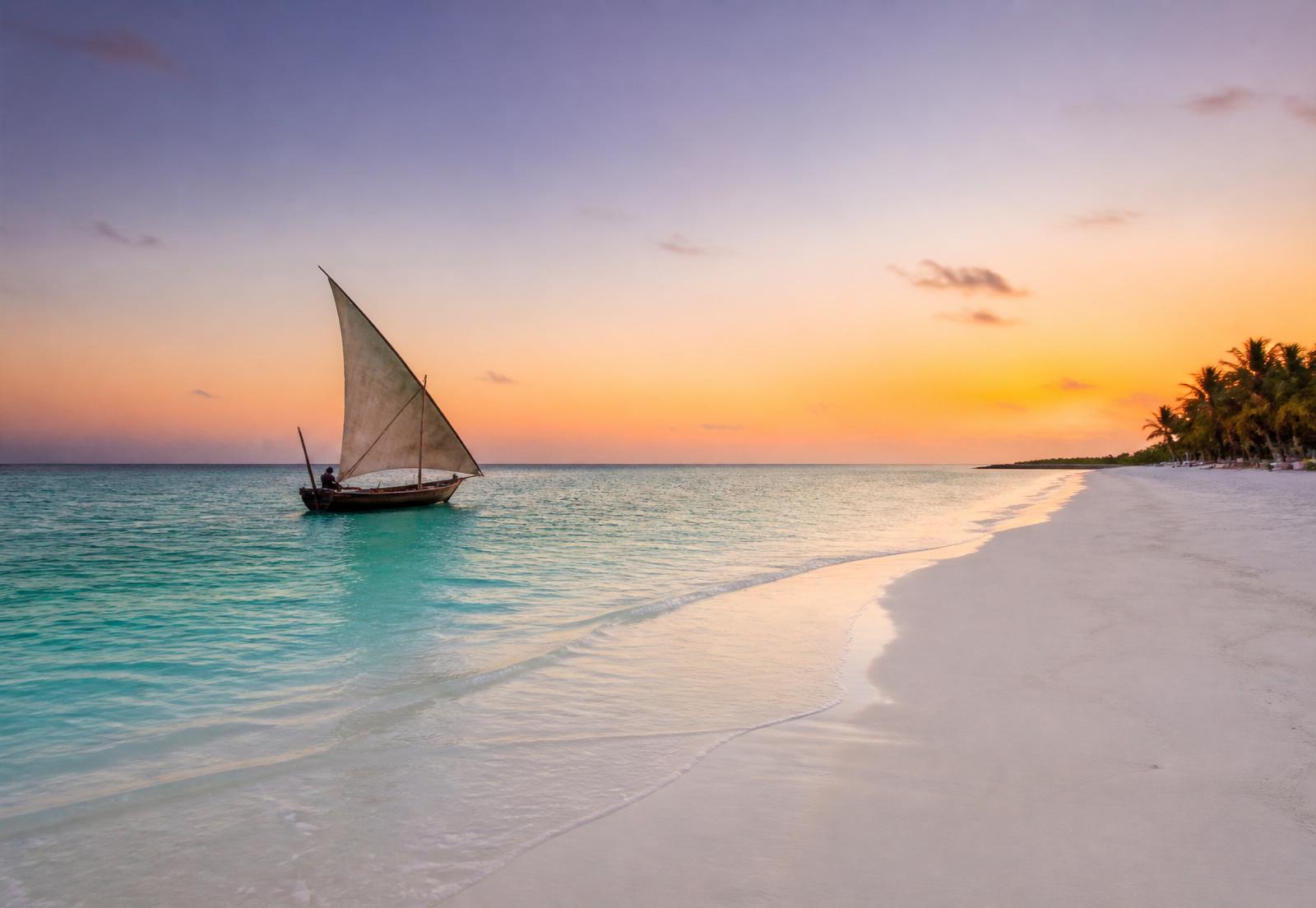 Dhow tradicional navegando ao amanhecer nas águas de Zanzibar